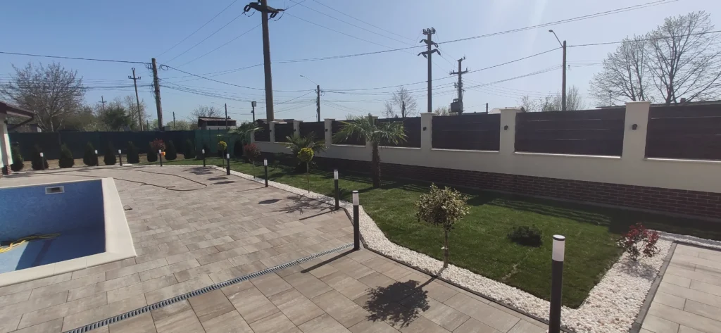 Grădină rezidențială amenajată cu gazon, și plante decorative