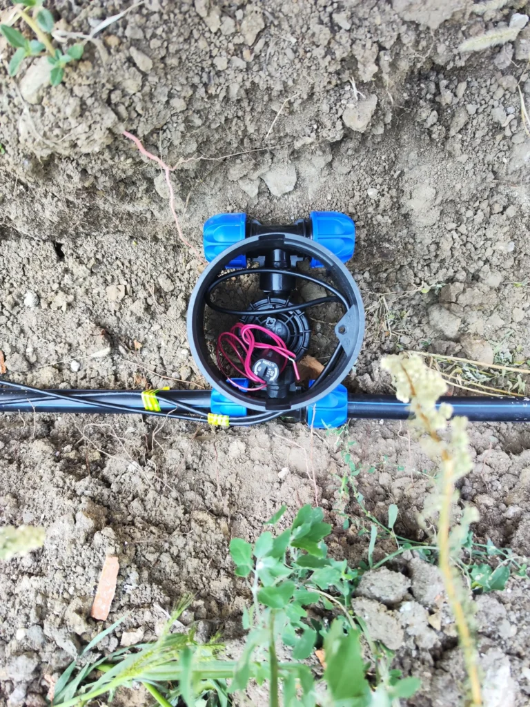 Electrovalvă cu conexiuni electrice și hidraulice montată în căminul (valve box) sistemului de irigații, instalare Verdara Solutions.